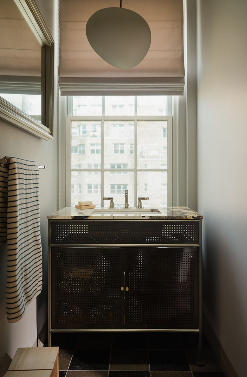 Powder room with a perforated-metal vanity, a marble top and a city-view window