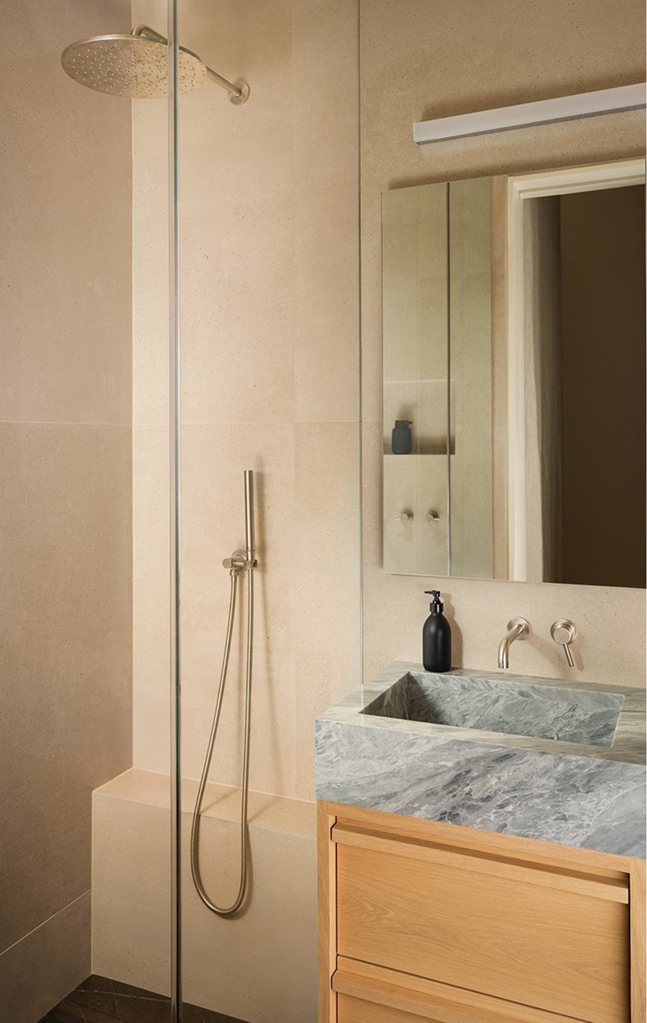 Bathroom with a glass walk-in shower and an oak vanity with a carved grey marble sink