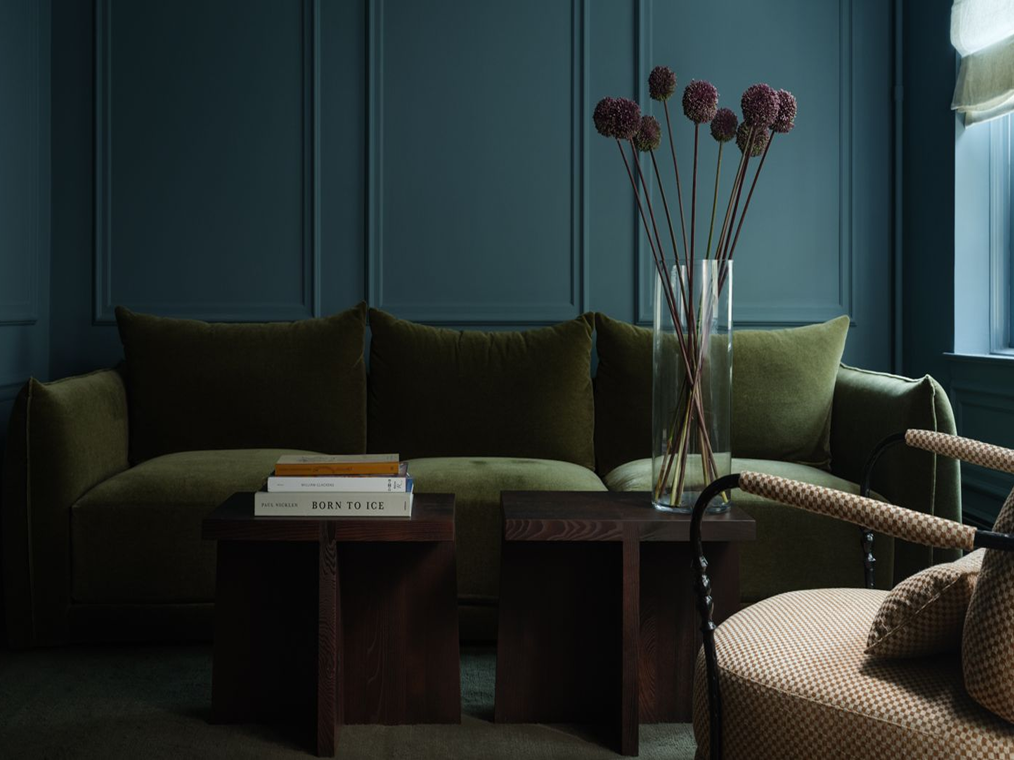 Study with an olive-green velvet sofa against deep blue-green panelled walls