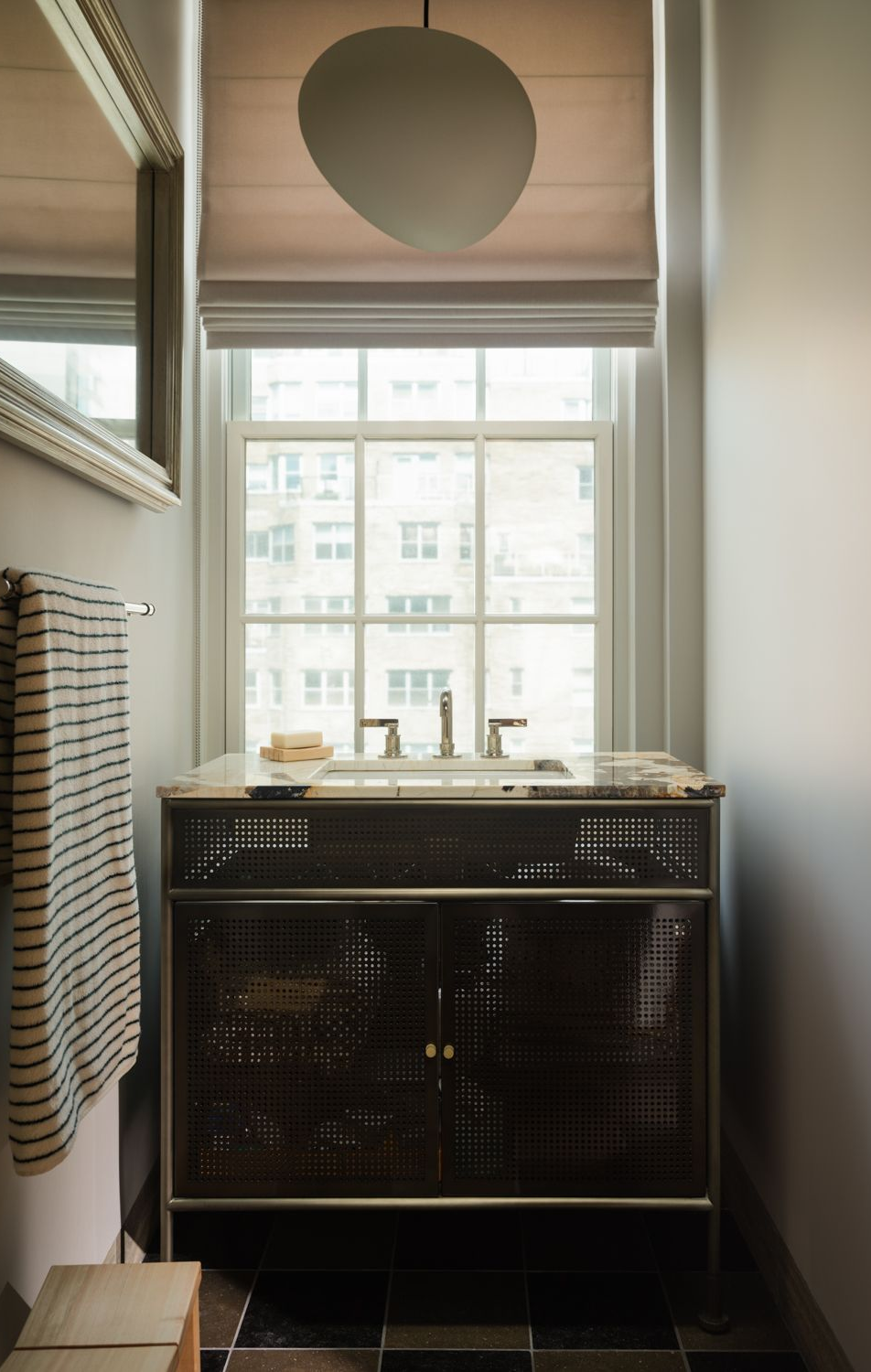 Powder room with a perforated-metal vanity, a marble top and a city-view window