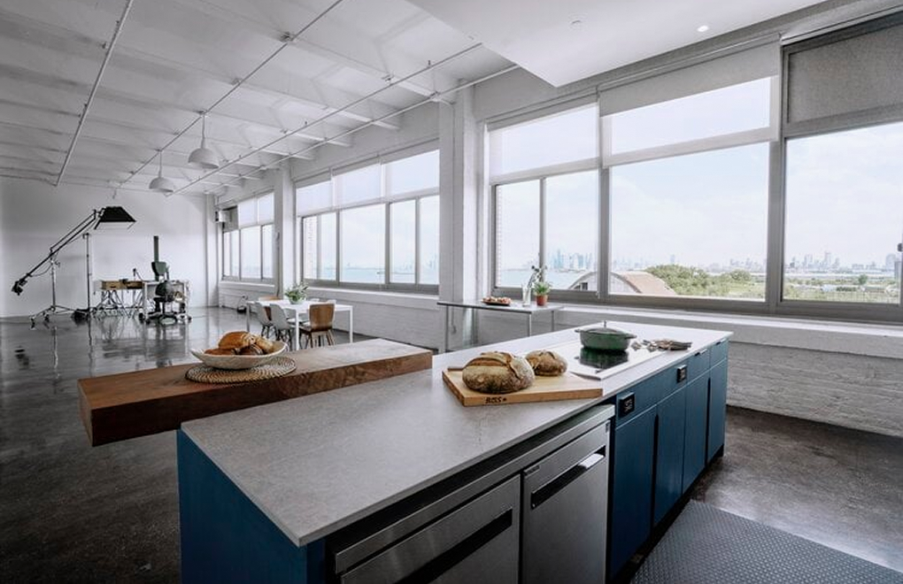 Industrial loft with a blue kitchen island and skyline views — Brooklyn commercial loft renovation