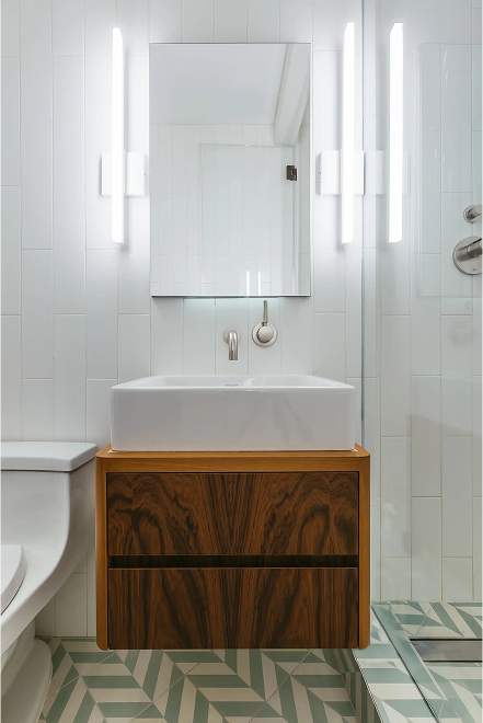 White bathroom with a walnut floating vanity and green patterned floor tile — Brooklyn Heights renovation
