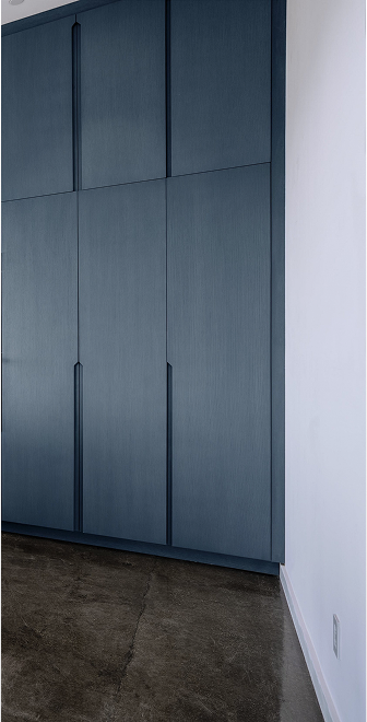 Blue cabinetry wall on a polished-concrete floor
